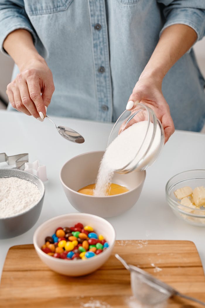 A close-up of mixing ingredients for a homemade dessert with sugar and colorful candies.