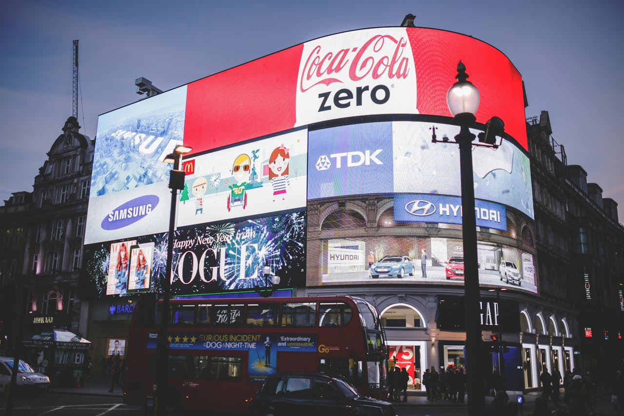 team-03 Night view of Piccadilly Circus in London with bright billboards and a red double-decker bus.